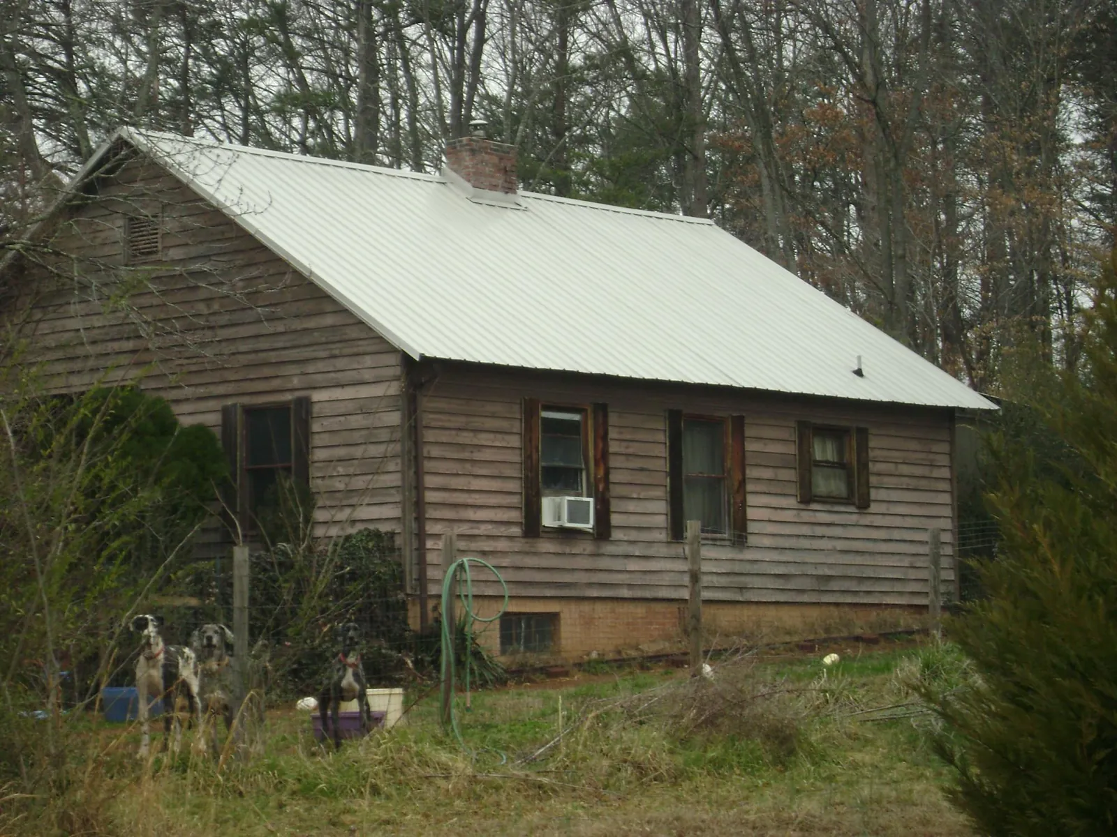 White metal roof on an old wood sided farmhouse, from a Metal Roof Installation job in Whitewater